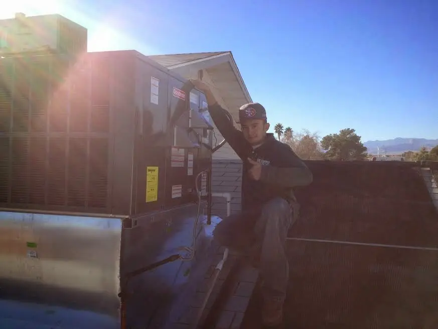 HVAC technician performing AC Tune-Up on a rooftop unit in Ocean Pointe